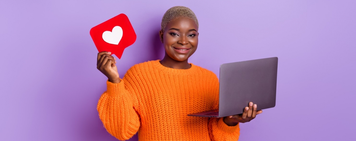 Femme tenant un ordinateur et un panneau avec un coeur