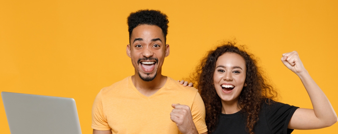 2 personnes joyeuses avec un ordinateur