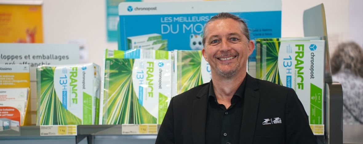 Homme souriant dans l'espace commercial d'un bureau de poste