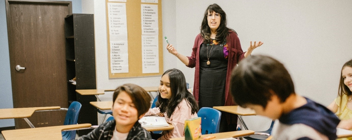 Photo d'un bénévole avec des élèves dans une classe