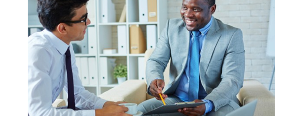 2 hommes en costume assis dans des fauteuils et discutant